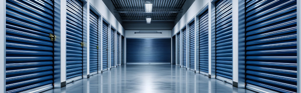 interior of a modern storage facility featuring blue rolling doors and a clean floor perfect for storage solutions and secure storage