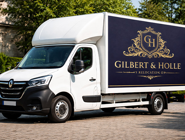 white moving truck with logo and branding for Gilbert and Holle relocation services parked in a scenic area with visible greenery and sunlight ideal for two shipments or relocations