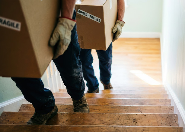 three professional movers in branded uniforms stand confidently in front of a moving truck showcasing reliable service and teamwork for your next move